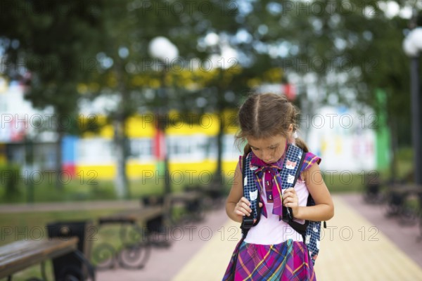 Sad, upset girl near the school with a backpack. Fatigue from classes, resentment, lessons not learned, a bad mark. Back to school. Copy space