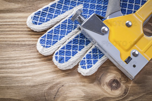 Construction stapler safety working gloves on wood board directly above