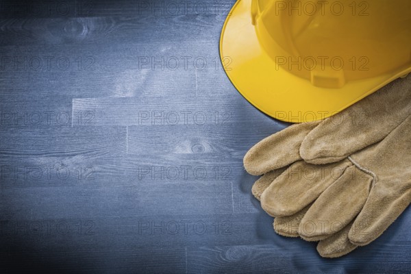 Protective gloves building helmet on wooden board construction concept