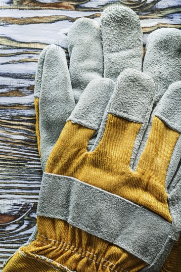 Protective gloves on wooden board top view