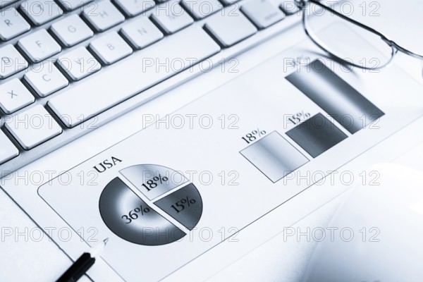 Business workplace with keyboard mouse and papers with graphs and diagrams