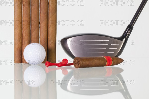 Golf driver and different cigars on a glass table