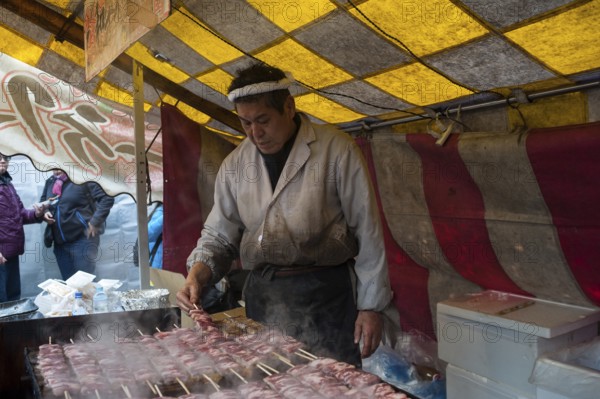 24.12.2017, Kyoto, Japan, Asia, A man prepares freshly roasted yakitori beef skewers at a stall in the park of Fushimi Inari Taisha Sanshuden