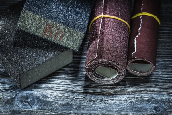 Rolled abrasive paper blocks on vintage wooden board
