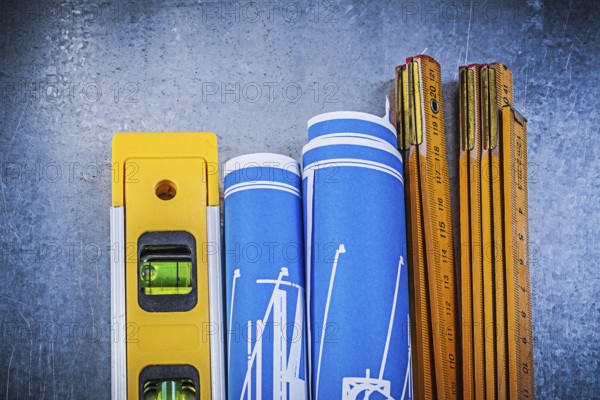 Wooden meter blue construction drawings level on metallic background