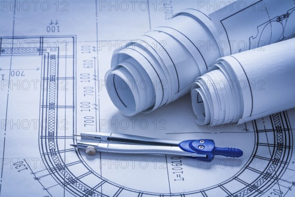 Rolled up construction sketches and drawing compass building concept
