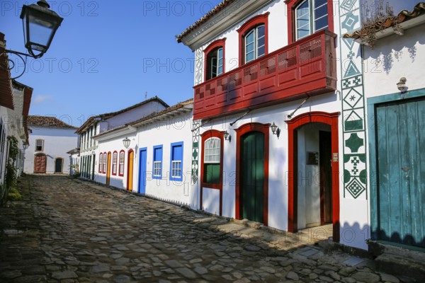 Typical cobblestone street with decorative and colorful colonial buildings in late afternoon light in historic town Paraty, Brazil