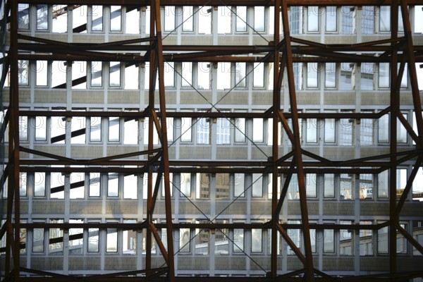 A heavy iron construction supports a single wall of a demolished tower block