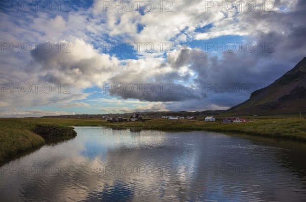 Quiet summer evening on the coast of Iceland. Small pond in the fishing settlement of Arnastapi