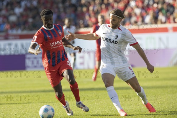 Football match, Sinlord CONTEH 1. FC Heidenheim left on the ball in a duel with Lucas HÖLER SC Freiburg, football stadium Voith-Arena, Heidenheim