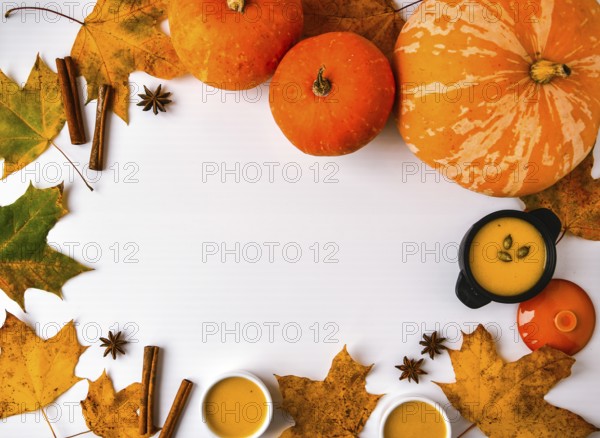 Autumn food. Frame of pumpkin puree soup, leaves. Top view. Autumn harvest, pumpkins, leaves on grey as abstract background. View from above. Thanksgiving day. Flat lay. Copy space