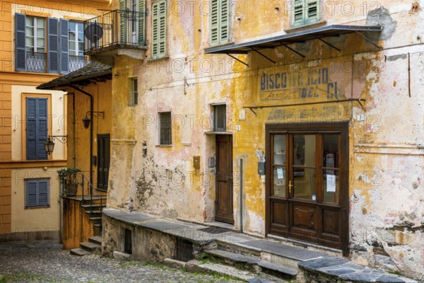 Orta San Giulio, Italy, 13 March, 2023: colorful shabby buildings in the old town center of Orta San Giulio