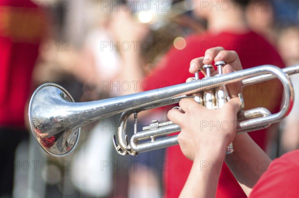 A jazz trumpeter plays of his trumpet in the brass band during a carnival live event. Blurry close up plan of trumpeter plays jazz.