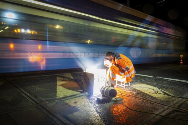 Worn tram tracks are made fit for traffic using construction welding. In order not to disrupt traffic too much, this work is carried out at night by a construction crew, Dresden, Saxony, Germany