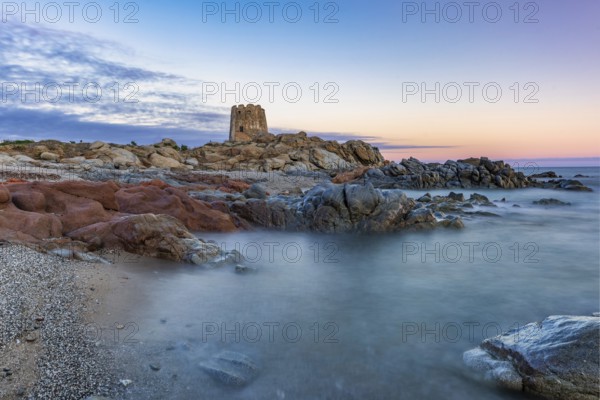Old historic tower from the 16th century and rocks at sunset on the beach, long exposure, Torre di Bari, Barisardo, Ogliastra, Sardinia, Italy