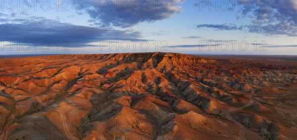 Aerial panorama of textural colorful striped canyons Tsagaan suvarga, White stupa at sunrise. Ulziit soum, Dundgovi province, Mongolia