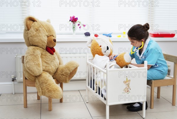 Caucasian girl nursing her teddy bear themes of daydreaming imagination ambition