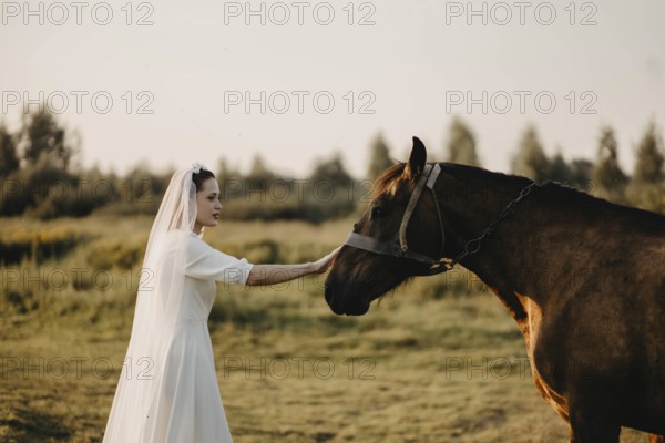 A bride gently touching a horse in a serene natural landscape, symbolizing harmony