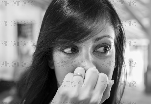 Close up portrait of young woman looking for something. Defocused blurry background