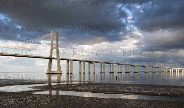 Vasco da Gama Bridge at sunset with dramatic cloudy sky in Lisbon