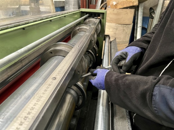 Technician worker placing the blades of a machine to cut steel coils. Industrial environment and business concept