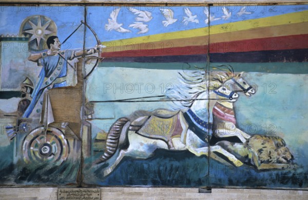Wall mural depicting Saddam Hussein shooting an arrow from a bow while riding down a lion from a Roman war chariot, painting since destroyed, Mosul, Iraq, Middle East/Darstellung Saddam Husseins als Fahrer eines römischen Streitwagens (Bild mittlerweile zerstört) an einer Wand in Mossul, Irak