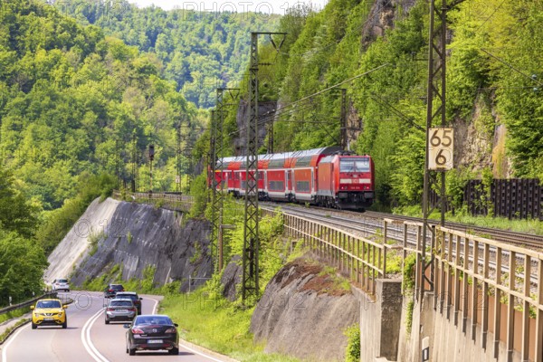 Regional express RE5 en route on the winding railway line of the Geislinger Steige. Landscape along the railway line in spring. Amstetten, Baden-Württemberg, Germany