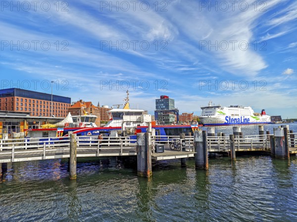 Maritime atmosphere in the harbour at the end of the Kiel Fjord, jetty, liner ships, Sweden ferry of the Stena Line at the quay, seafaring, glass building and brick architecture, dolphins, sunshine, cirrocumulus clouds, blue sky, Baltic Sea, Kiel, Schleswig-Holstein, Germany