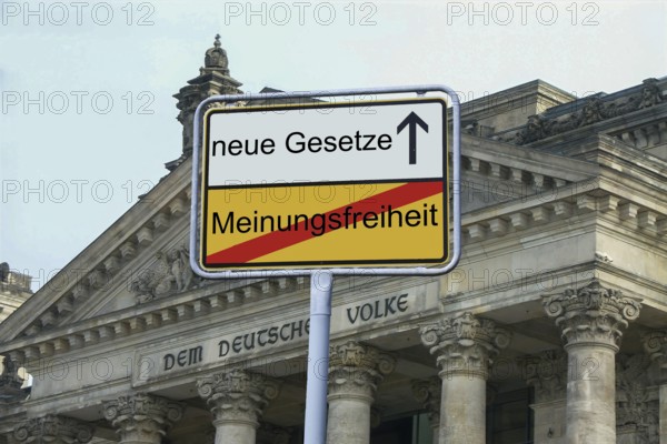 (Photomontage) : Exit sign in front of the inscription NEUE GESETZE / MEINUNGSFREIHEIT in front of the Reichstag building in Berlin