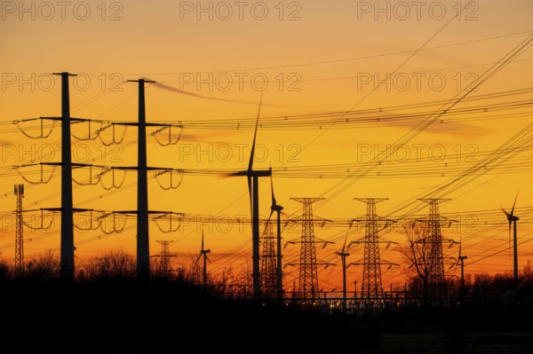 High-voltage electricity pylons, transmission towers and wind turbines at sunset near the Borssele Nuclear Power Station, Zeeland, Netherlands
