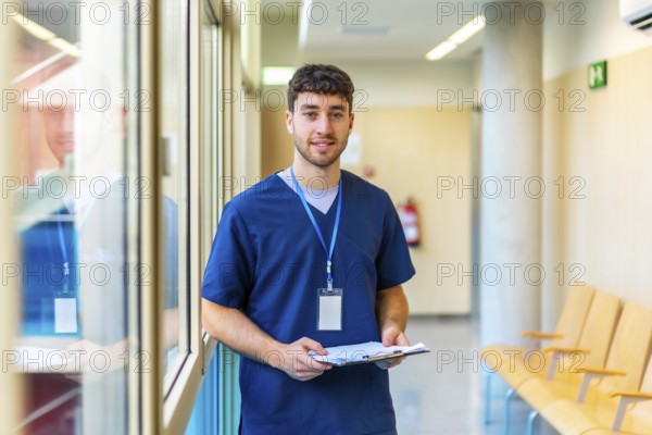 Portrait of a confident male nurse reviewing patient files, showcasing professionalism and healthcare expertise in a modern medical facility