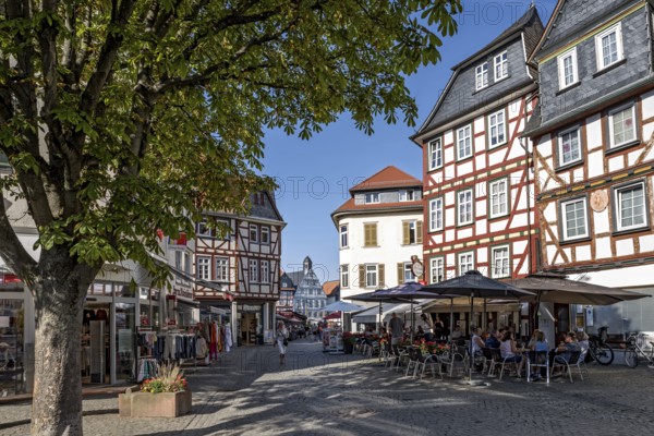 Shops, shops, street cafés, half-timbered houses, busy shopping street, Weiseler Strasse, old town hall at the back, pedestrian zone, historic old town, Butzbach, Wetterau, Hesse, Germany