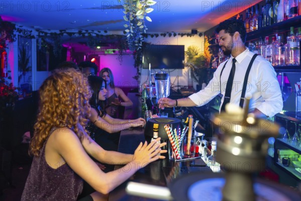 Bartender mixing vibrant cocktails in a trendy nightclub, serving young women at the bustling bar counter amid lively music and colorful lights