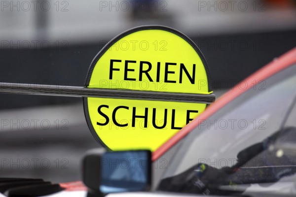 (Photomontage) Summer holidays symbol image: Lollipop at motorsport with changed text HOLIDAYS / SCHOOL