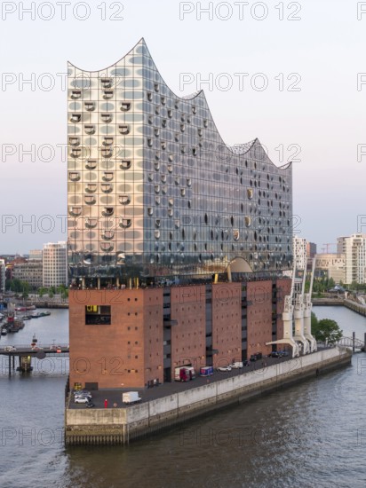 The Elbphilharmonie concert hall in Hamburg is reflected in the glass design above the historic Kaispeicher warehouse, Hamburg, Germany