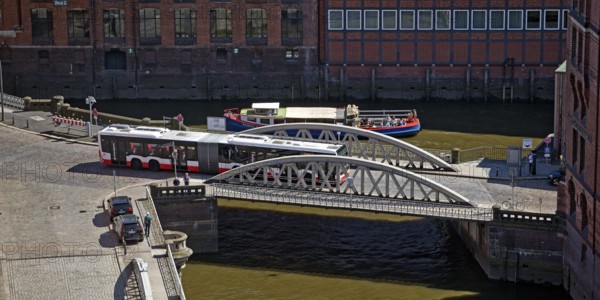 An articulated bus on the small Pickhuben bridge and a ship on Brooksfleet seen from above, Speicherstadt, Hamburg, Germany
