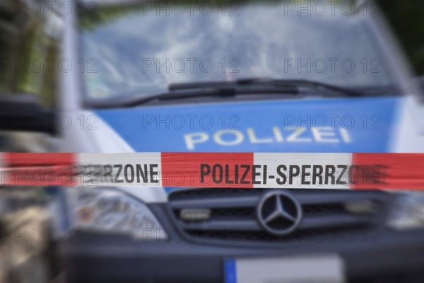 (Photomontage) Symbolic image of a police operation: police cordon in front of an emergency vehicle