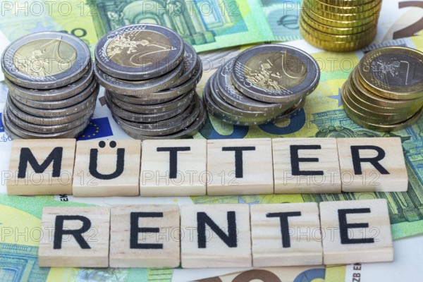 Mothers' pension Symbolic image: letter blocks on euro banknotes show the word MÜTTERRENTE (mothers' pension)