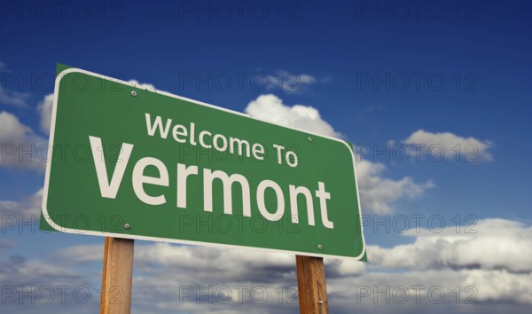 Welcome to vermont green road sign over blue sky with some clouds