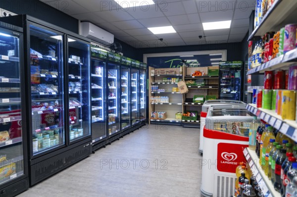 Modern supermarket with illuminated refrigerated shelves and numerous products, Tante M, self-service shop, Enzklösterle, Calw district, Black Forest, Germany