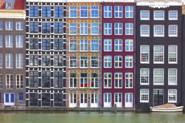 Holland, Amsterdam Damrak canal houses with scenic bridges in historic center, UNESCO Heritage site