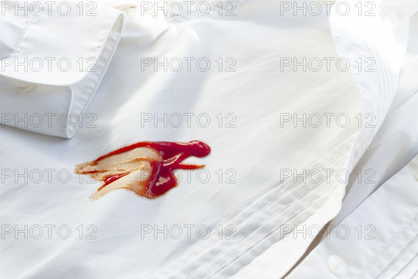 White shirt stained with ketchup, no people, close-up, selective focus