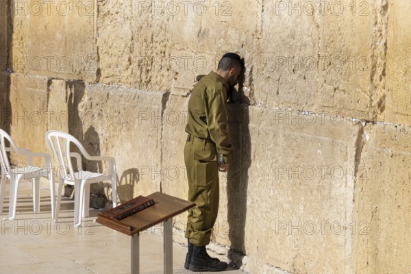 Jerusalem, Israel, 15 April, 2022: Israeli soldier praying in front of Sacred Western Wall in Jerusalem Old City Jewish Temple
