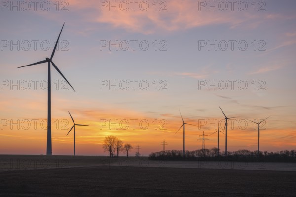 Wind farm at sunset, the sky is bathed in soft pink and orange, near Ulm, Swabian Alb, Baden-Württemberg, Germany