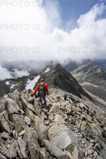 Mountaineer on the summit of Lasörling, cloudy mountain landscape, Lasörling Group, Hohe Tauern National Park, East Tyrol, Tyrol, Austria