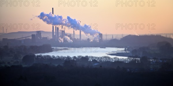 View in front of sunrise from the Rheinpreussen spoil tip onto the Rhine in Duisburg with the Thyssen Krupp plant in Bruckhausen, Germany