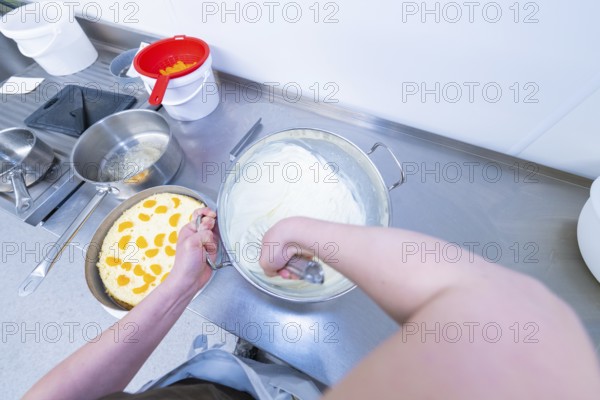 Person preparing cream in a bowl next to a cake base, cake baking, Haselstaller Hof Cafe Kuh, Wildberg, Black Forest, Germany
