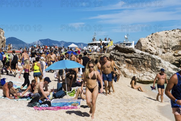 Crowds on the beach, Cala mariolu, Gulf of Orosei National Park, Parco Nazionale del Gennargentu e del Golfo di Orosei, Baunei, Nuoro, Sardinia, Italy