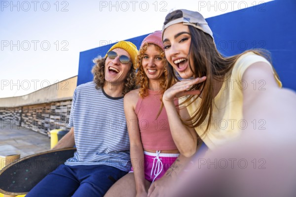 Three joyful skaters enjoying a sunny day, capturing a fun selfie against a vibrant blue wall, celebrating friendship and youthful energy