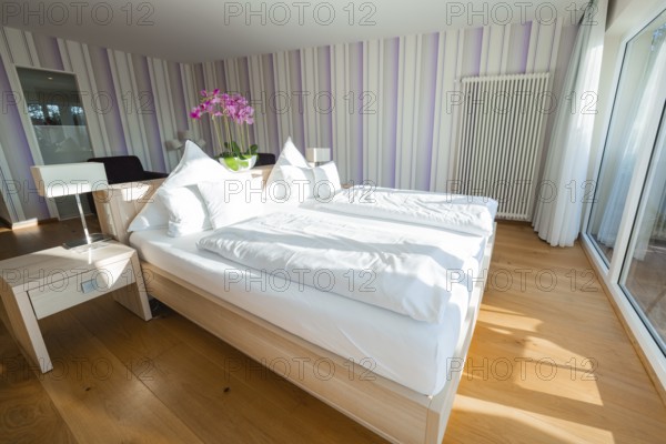 Bright bedroom with double bed, wooden floor and purple striped walls, Hotel Krone Lamm, Zavelstein, Black Forest, Germany
